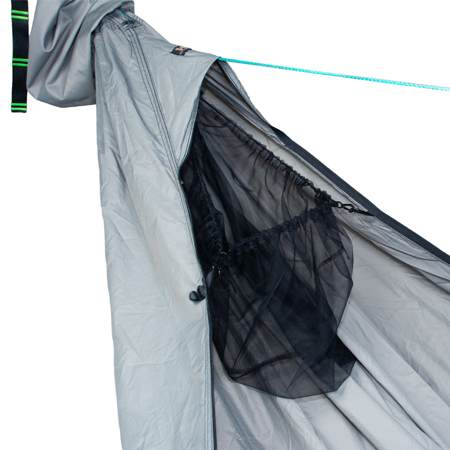 An empty, black mesh storage pocket attached onto an erected hammock.