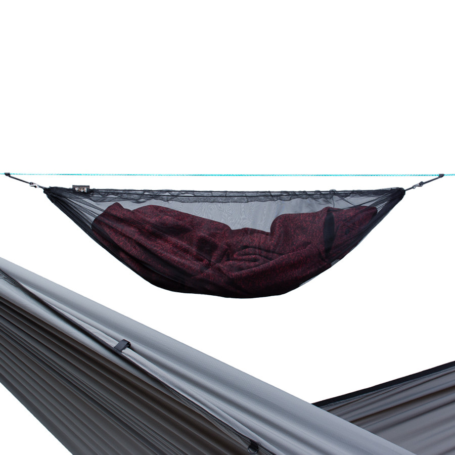 Black ridgeline storage net with a blanket stored inside hung above a hammock.